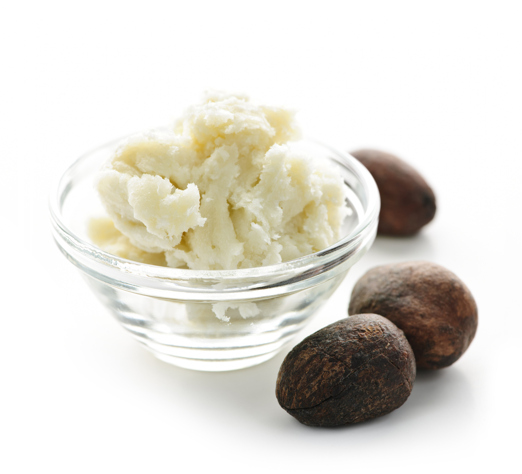 Shea nuts and sheabutter in glass bowl isolated on white