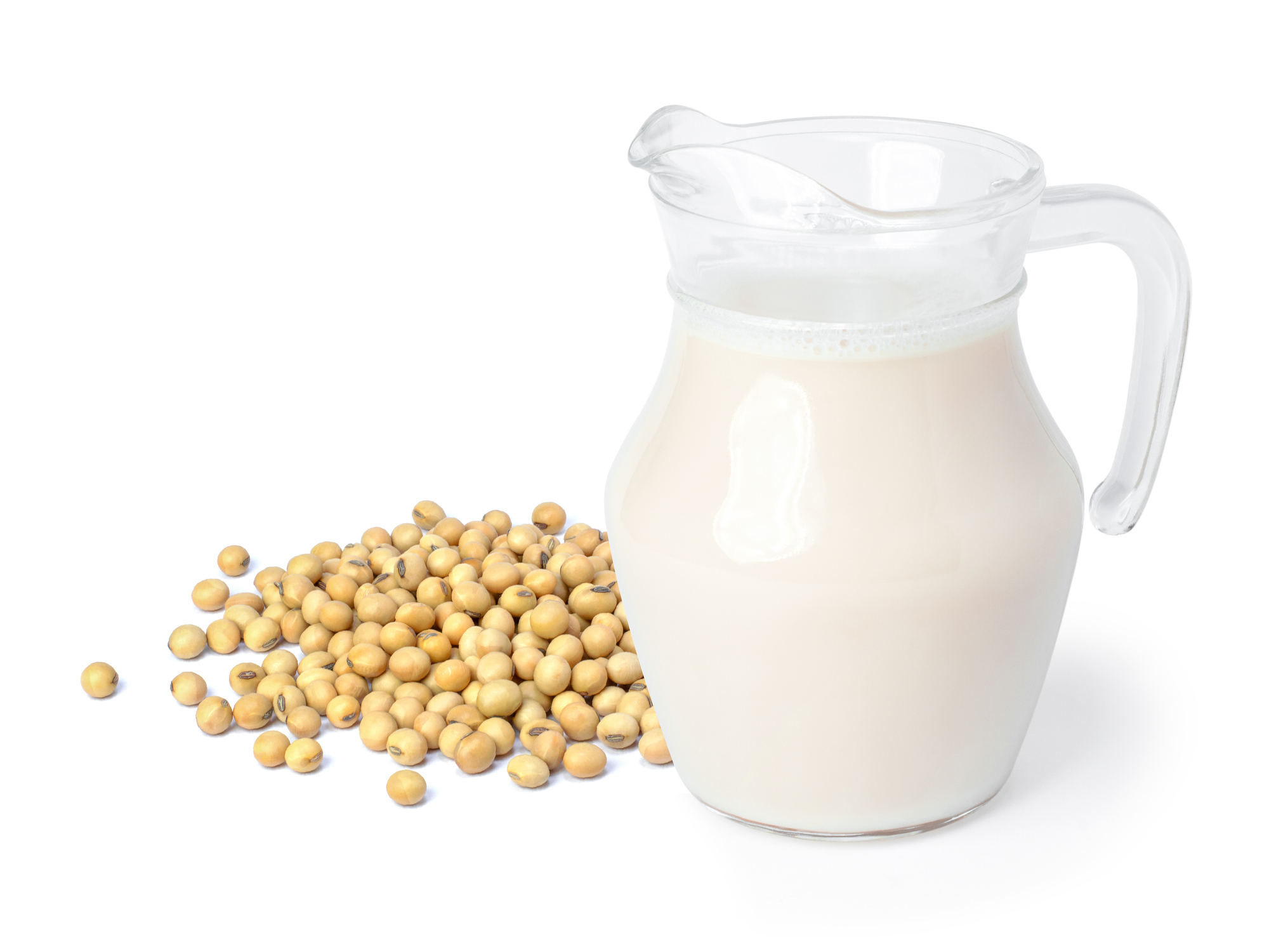 Soymilk in glass jug with soybeans isolated on white background.